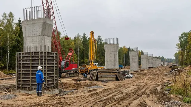 Бетонщик у опалубки опоры эстакады на стройке